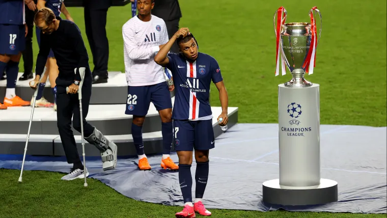 Mbappé passando ao lado da taça da Champions League após o PSG perder a final de 2019/20